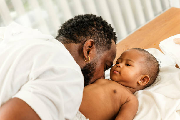 istock A tender moment between a father and baby, showcasing love and connection in a serene setting. Happy diversity family and newborn bathing concept. 2190354537