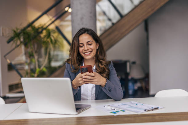 istock Smiling businesswoman using phone in office 2190354738