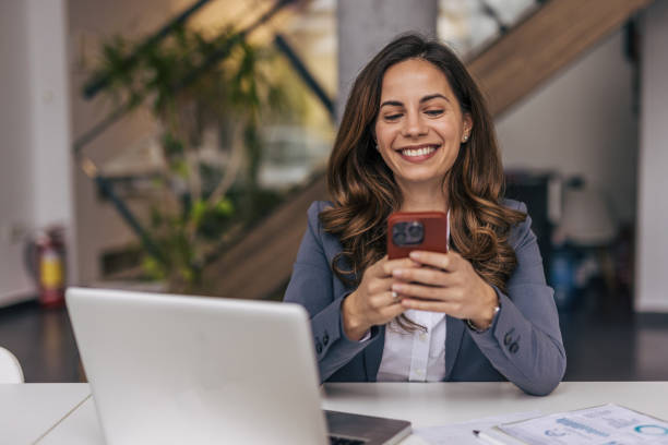 istock Smiling businesswoman using phone in office 2190354904