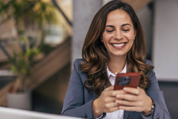 istock Smiling businesswoman using phone in office 2190355012