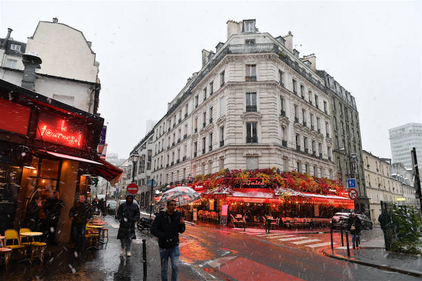 Paris, France-11 21 2024: Pedestrians walking in the snow in the Montparnasse district of Paris, France.