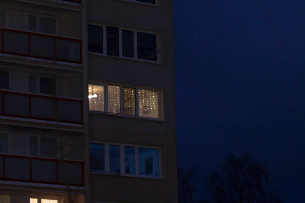 A tall building that has numerous windows is beautifully illuminated during the nighttime hours, creating a stunning urban scene at night