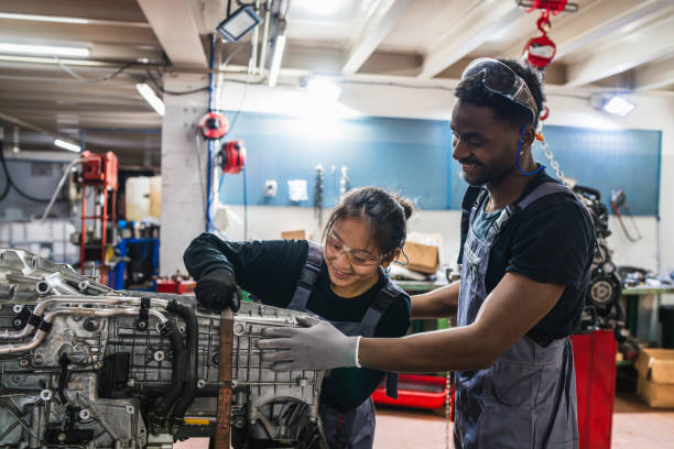 istock Mechanics working together on car engine repair in auto shop 2190363186