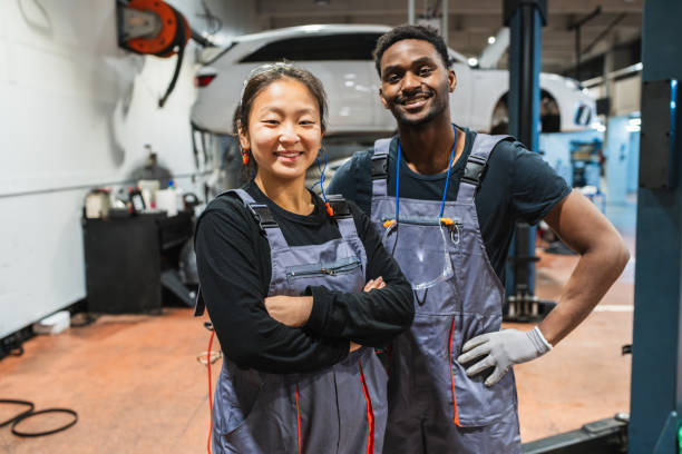 istock Two smiling mechanics posing in auto repair shop 2190363360