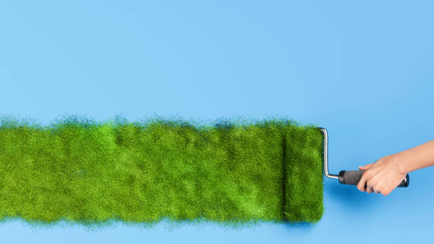 istock Hand painting green grass with paint roller on blue background 2190364988