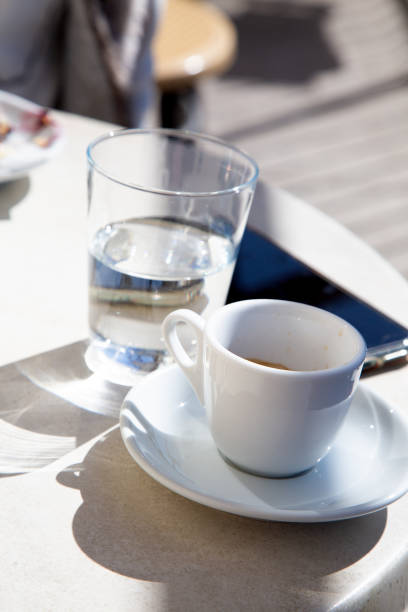istock On a table, there is a cup of coffee alongside a glass of water 2190366290