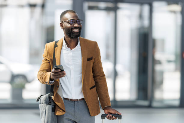 istock Business traveler with a suitcase using phone in the train station lobby 2190368369