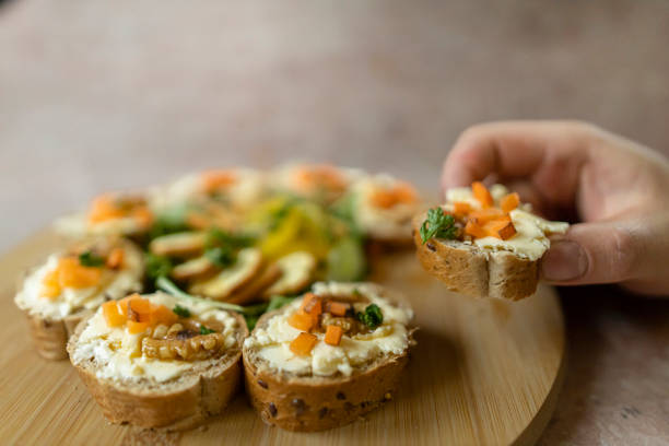 Butter on bread and crackers. Side view. Man hand taking a food