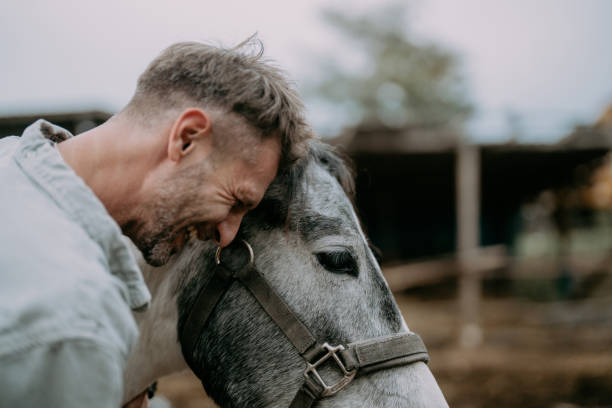 Photo of a mid adult men sharing affection with his favourite horse at the ranch