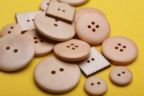istock Wooden buttons on a yellow background close up 2190376978