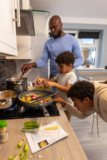 istock Father and Sons Concentrating on Cooking Dinner 2190377206
