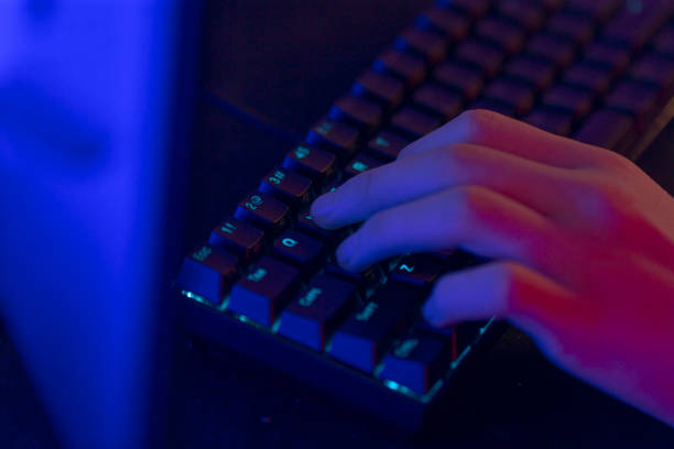 istock A person is diligently typing away on a computer keyboard in a dark room 2190378229