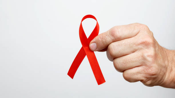 istock World AIDS Day. Man holding red AIDS awareness ribbon 2190379172