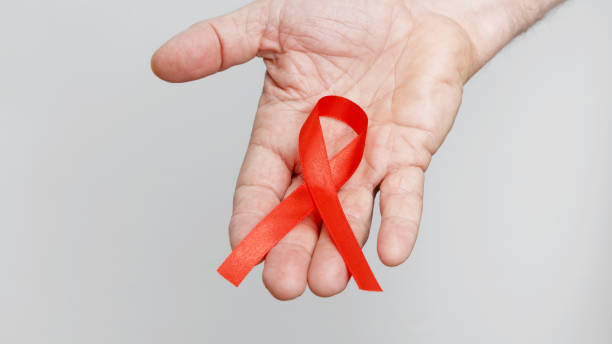 istock World AIDS Day. Man holding red AIDS awareness ribbon 2190379174