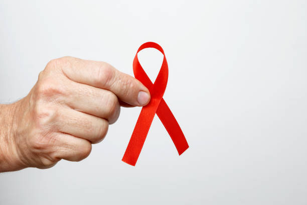 istock Man holding red AIDS awareness ribbon. World AIDS Day 2190379179