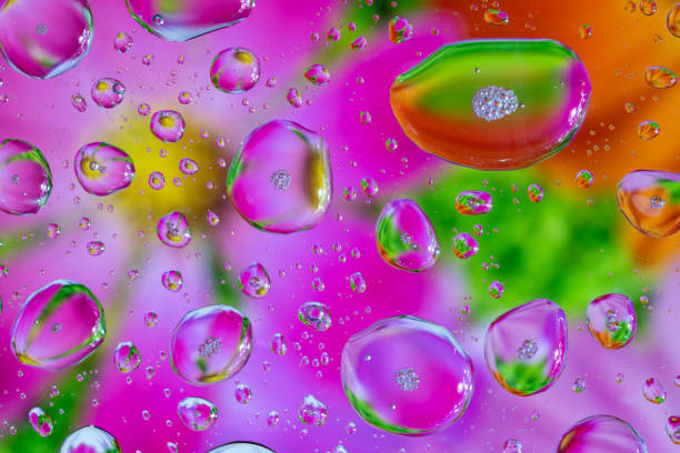 Splash of water drops on glass with colorful background.