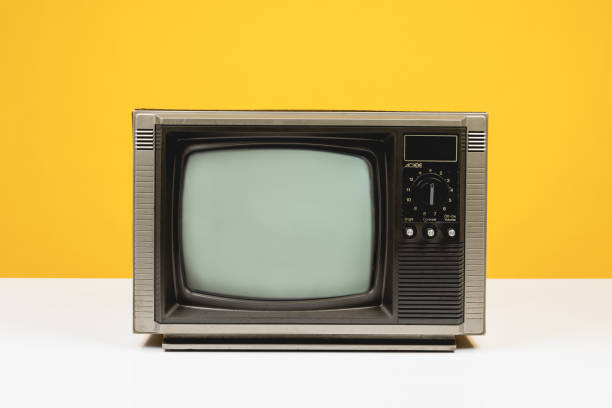 istock Old retro TV on white table with blank screen on yellow background, front view. 2190385224