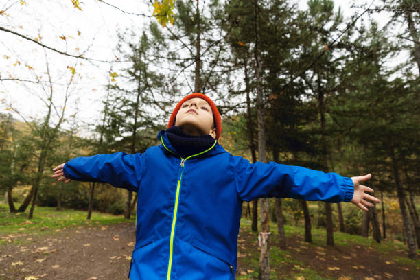 Child Enjoying the Crisp Autumn Air in a Forest Setting
