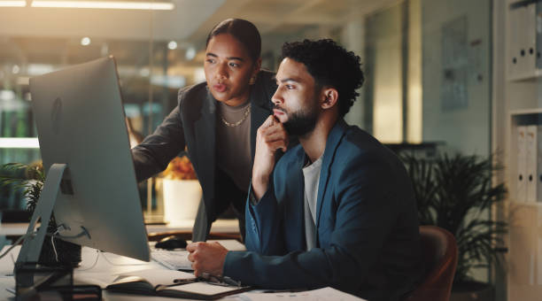 istock Man, woman and review by office computer at night for planning, point or advice for project management. Business people, partnership and team talk for feedback on overtime at startup creative agency 2190386142