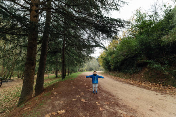 Child Enjoying the Crisp Autumn Air in a Forest Setting