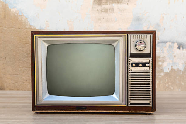 istock Retro old tv with blank screen on wooden table with old concrete wall background, front view 2190386251