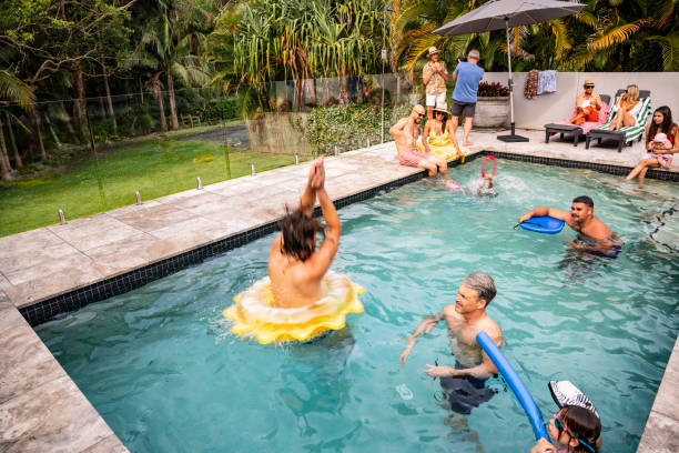 istock Adults and children playing in backyard swimming pool 2190386583