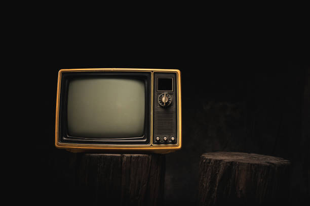 istock Front view of Retro red old TV on black tree stump on a black background in the studio. 2190387690