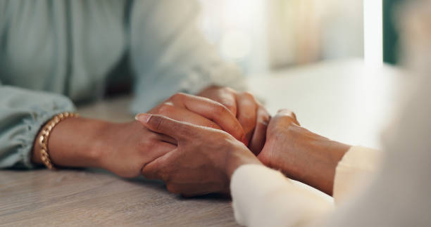 istock People, hands or empathy with therapist for counseling, understanding or therapy at office desk. Closeup, consultation or patient with touch for sympathy, emotion or support for grief, loss or advice 2190395785