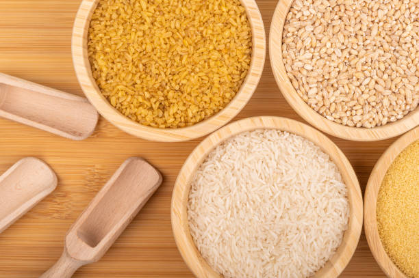 istock Assorted grains in wooden bowls with scoops on a bamboo surface 2190396180