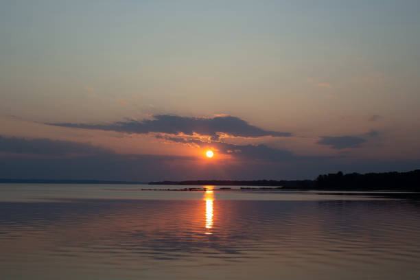 sunset with clouds and the sun reflecting off the water.