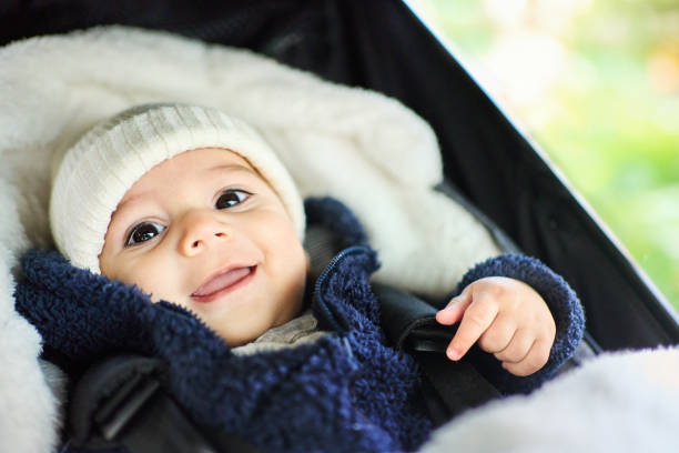 Adorable baby boy sitting inside his pram stock photo