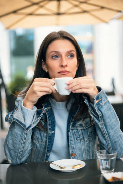 Pretty woman drinking a cup of coffee on a bar terrace stock photo