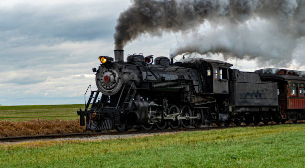 istock Historic Steam Train Traveling Through a Rural Landscape Under a Cloudy Sky 2190401525