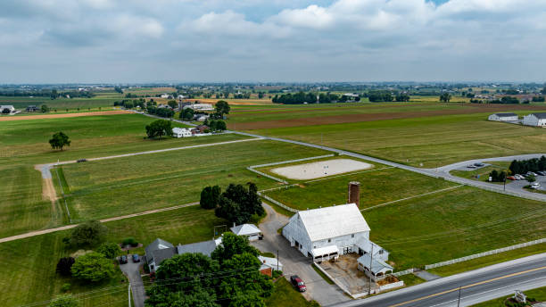istock Rural Landscape With Expansive Farmland and a White Barn Under a Cloudy Sky 2190401591