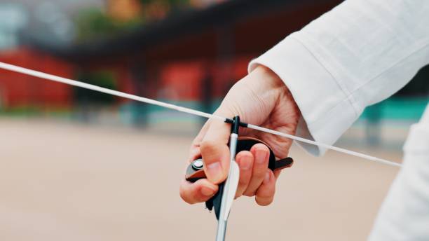 Archery, person and hands with arrow, bow or string for aim, skill or talent in preparation for precision or hunting in city. Closeup or professional archer with weapon for sport or combat