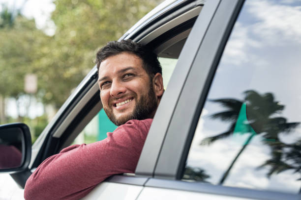 istock Man looking out of the driver's window in his rented car while sightseeing in Miami, USA 2190401708