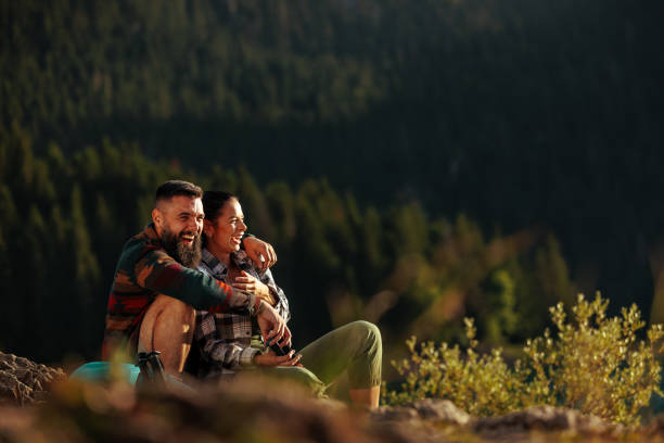 Couple enjoying the break from hiking on a hill top