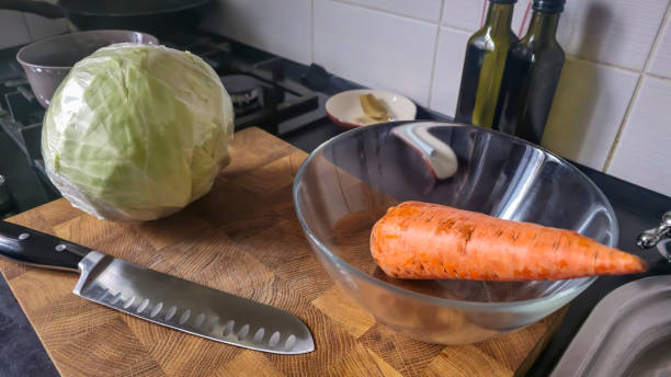 Cooking a cabbage and carrot dish at home in the kitchen. Step-by-step instructions. Kitchen interior.
