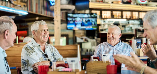 Senior friends meeting and chatting at restaurant table