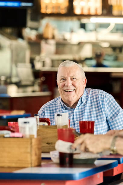 istock Smiling senior man sitting at restaurant table 2190410558