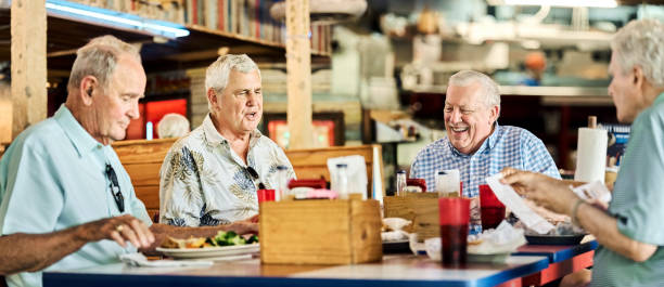 istock Group of senior friends interacting each other in cafe 2190410651