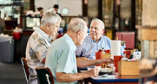 istock Senior men friends sharing meal and conversation at restaurant 2190410753