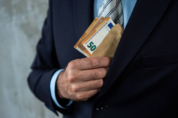 A man in a suit holding an envelope with cash, symbolizing bribery, corruption, or financial transactions in secrecy.