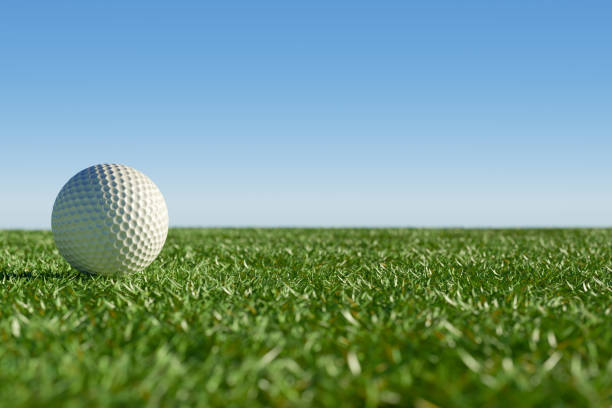 istock A closeup of a golf ball resting on lush green grass under a clear blue sky. 3d rendering 2190411348