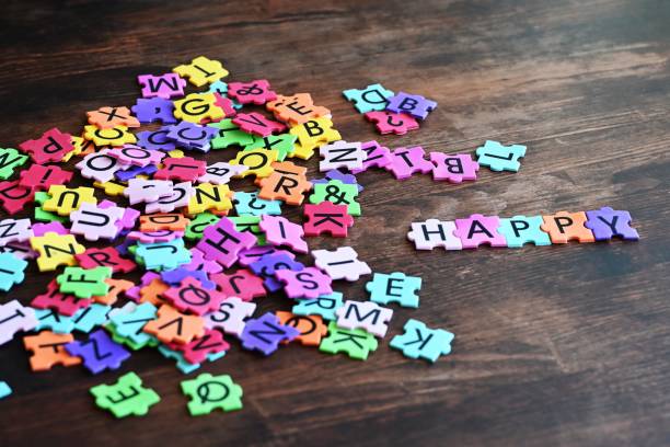 Colorful alphabet puzzle pieces on a wooden table spelling 'HAPPY'.