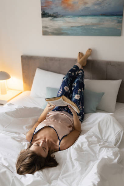 istock Woman reading a book in her bedroom 2190413199