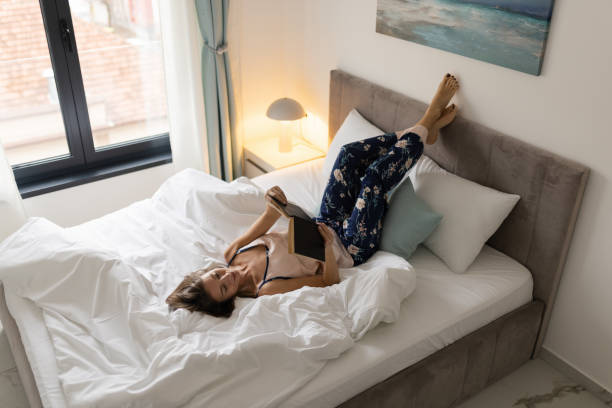 Woman reading a book in her bedroom