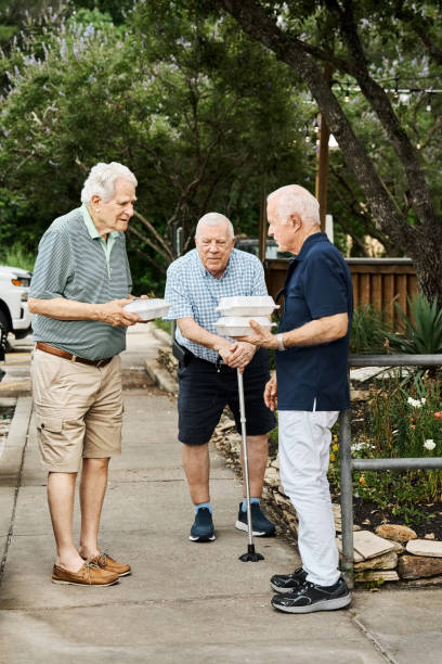 istock Senior friends with takeout containers standing outside and talking 2190413275