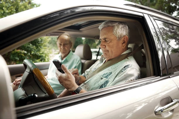 istock Senior man in drivers seat using phone for directions with friend 2190413727