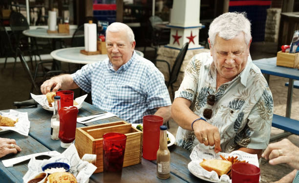 istock Senior men dining together at outdoor cafe on weekend 2190413817
